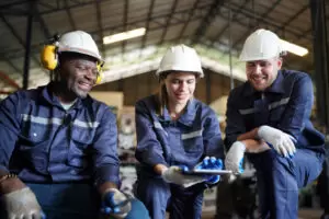 three employees sitting and smiling after being hired by a commercial staffing agency